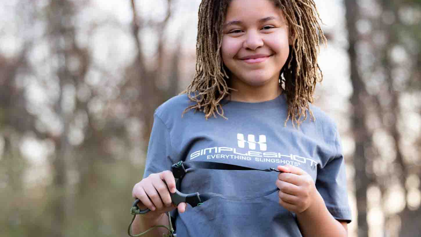 A Young Happy Girl Holding Our Slingshot During Her Camping Trip